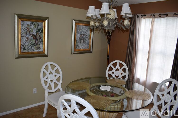 A dining room with a glass table and chairs.