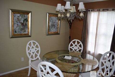 A dining room with a glass table and chairs.