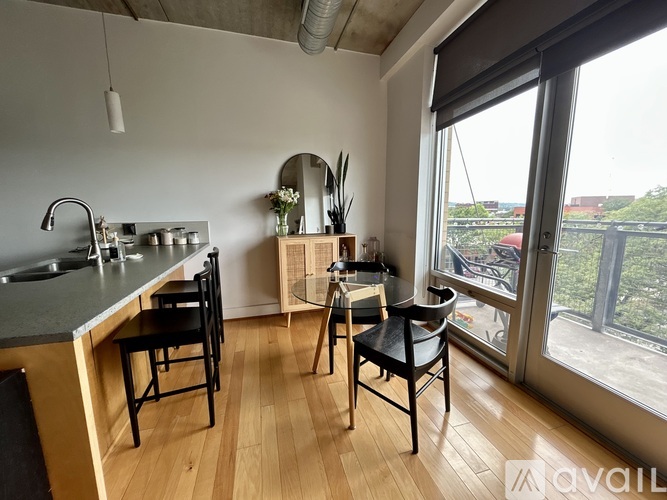 A kitchen with a table and chairs in front of a window.
