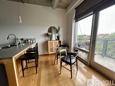 A kitchen with a table and chairs in front of a window.