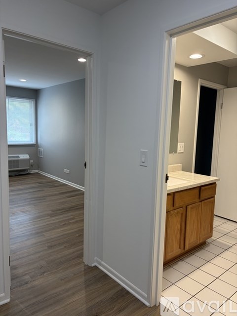 A kitchen with a white counter top and wooden cabinets.