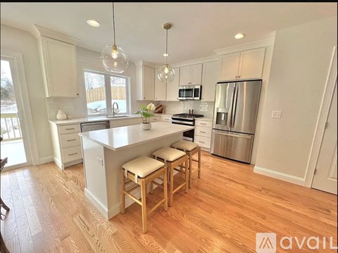 A kitchen with wooden floors and white cabinets.