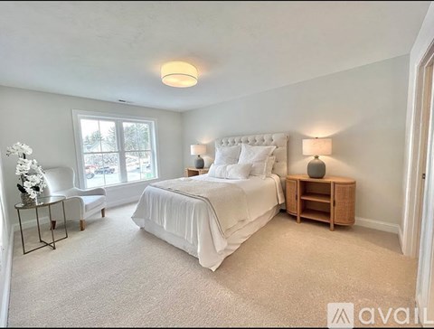 A bedroom with a large bed and a window.
