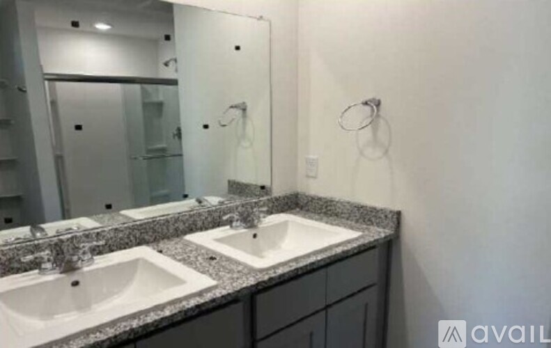 A bathroom with two sinks and a large mirror.