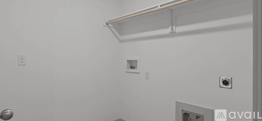 A white wall with a shelf and a small square hole.