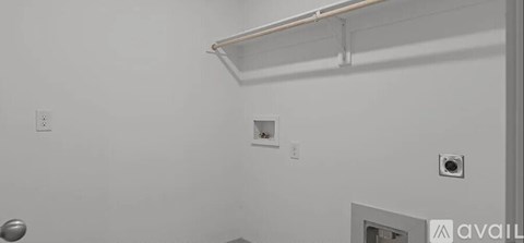 A white wall with a shelf and a small square hole.