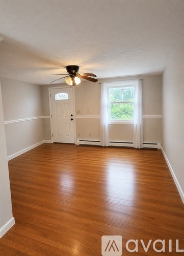 A room with wooden floors and a ceiling fan.