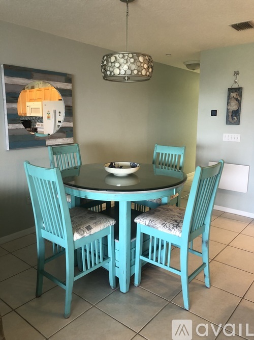 A dining room with a table and chairs.