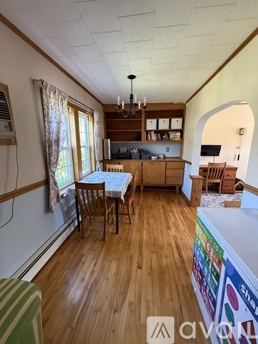 A kitchen with wooden floors and a dining table with chairs.