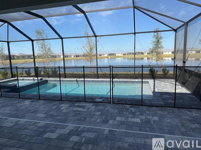 A glass-walled pool area with a view of a lake and trees.