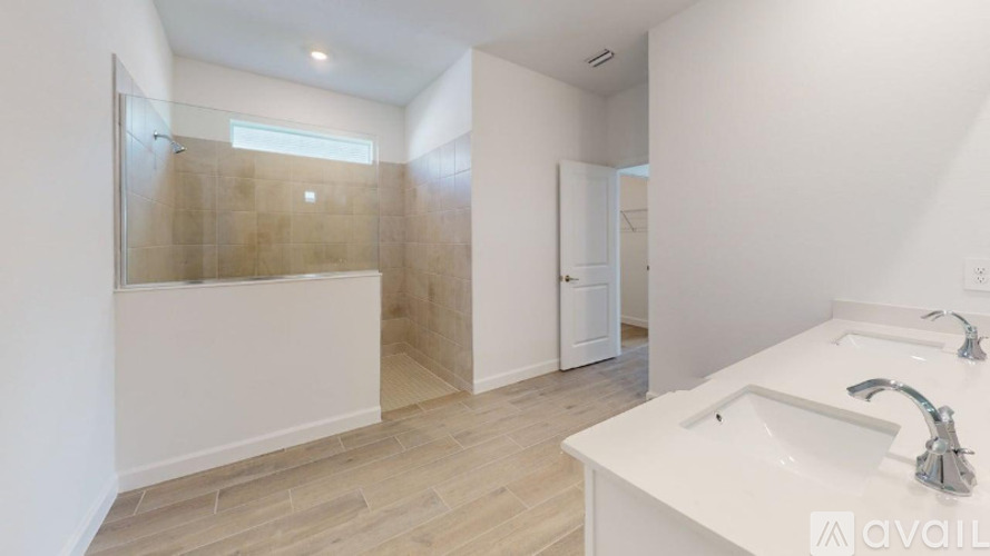 A bathroom with a walk-in shower and a double sink vanity.