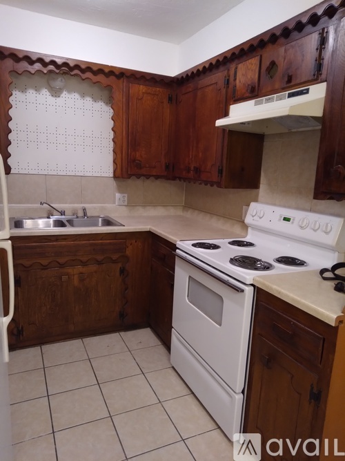 A kitchen with white appliances and wooden cabinets.