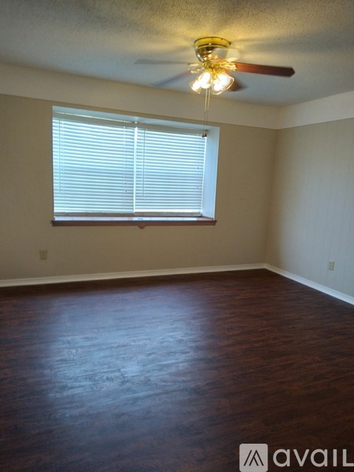A room with a ceiling fan and a window with blinds.
