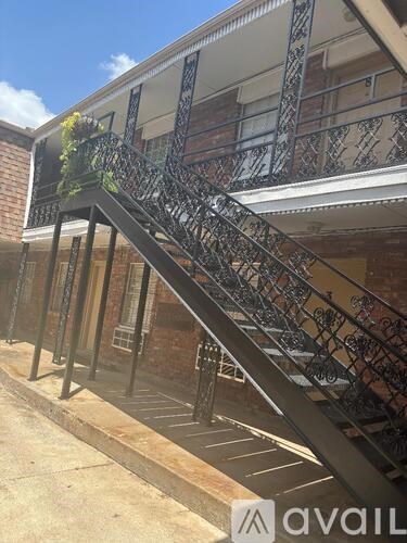 A black metal staircase with a metal railing and a plant on the top.