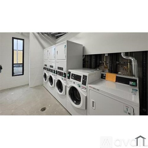A row of washing machines in a laundry room.