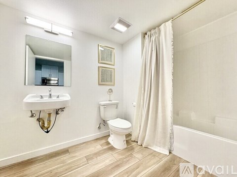 A bathroom with a toilet, sink, and bathtub.