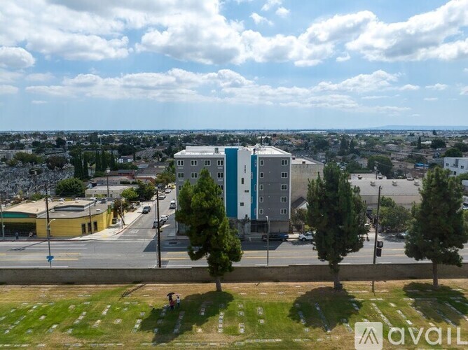 A view of a city from a high vantage point with buildings, trees, and a road.