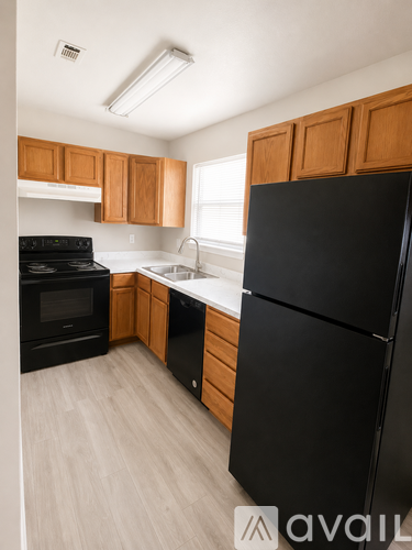 A kitchen with black appliances and wooden cabinets.