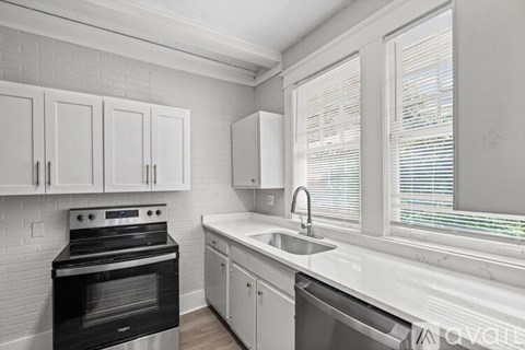 A kitchen with white cabinets and a black oven.