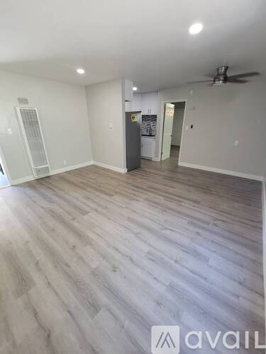 A room with wooden flooring and a ceiling fan.