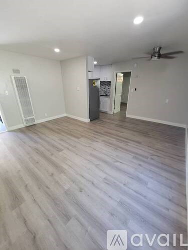 A room with wooden flooring and a ceiling fan.