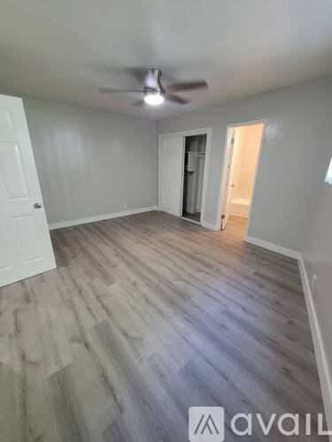 A room with a wooden floor and a ceiling fan.