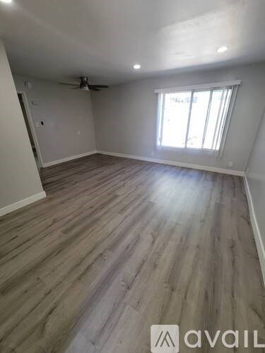 A room with wooden flooring and a window.