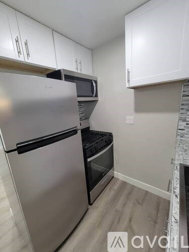 A kitchen with a stainless steel refrigerator and microwave.
