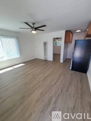 A room with wooden flooring and a ceiling fan.