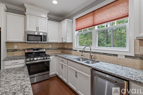 A kitchen with a stainless steel dishwasher and a microwave above the stove.