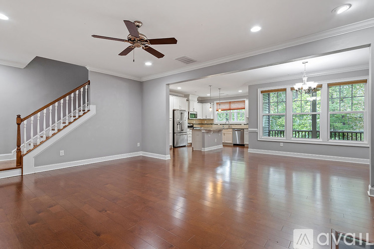A spacious room with a ceiling fan and wooden flooring.