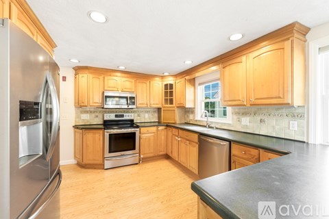 A kitchen with wooden cabinets and a black countertop.