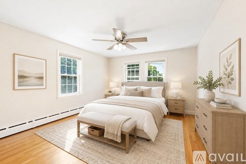 A bedroom with a bed, nightstand, and a ceiling fan.