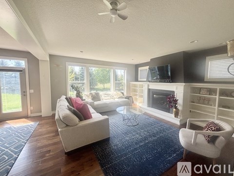 A living room with a white couch and a television on the wall.