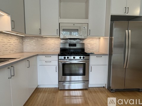 A kitchen with white cabinets and stainless steel appliances.