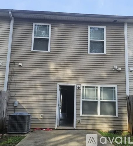 A two-story house with a garage door and a window on the first floor.