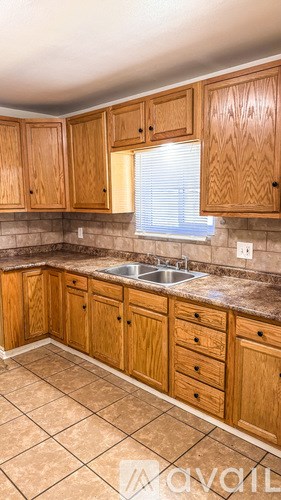 A kitchen with wooden cabinets and a tiled floor.