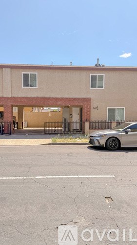 A car is parked in front of a building with a closed gate.
