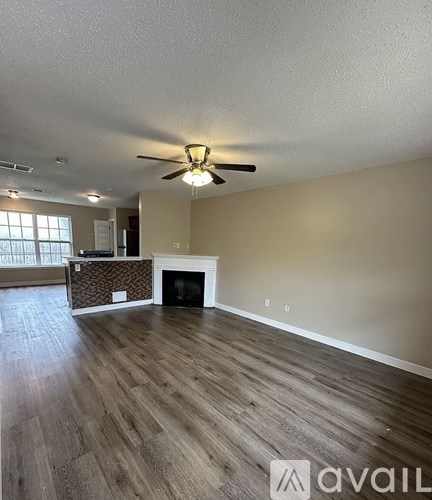 A living room with a fireplace and a ceiling fan.