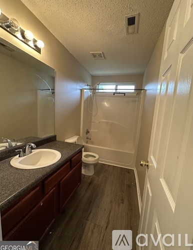 A bathroom with a sink, toilet, and shower.