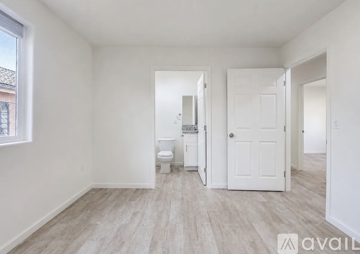 A spacious room with a toilet and a door.