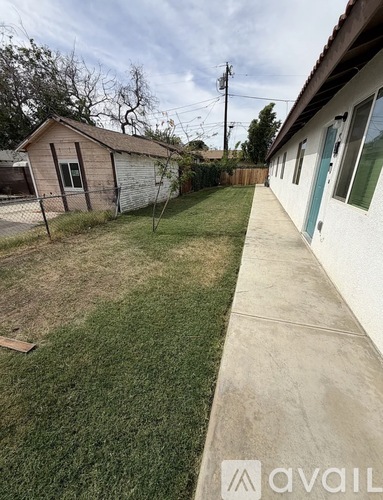 A backyard with a fence and a shed.