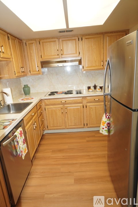 A kitchen with wooden cabinets and a stainless steel refrigerator.