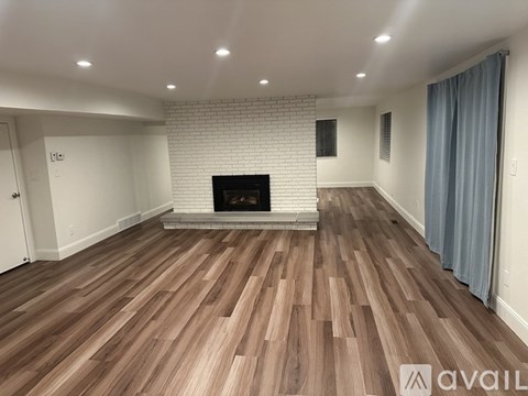 A living room with a fireplace and wooden flooring.
