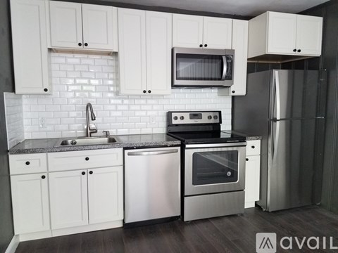A modern kitchen with white cabinets and stainless steel appliances.