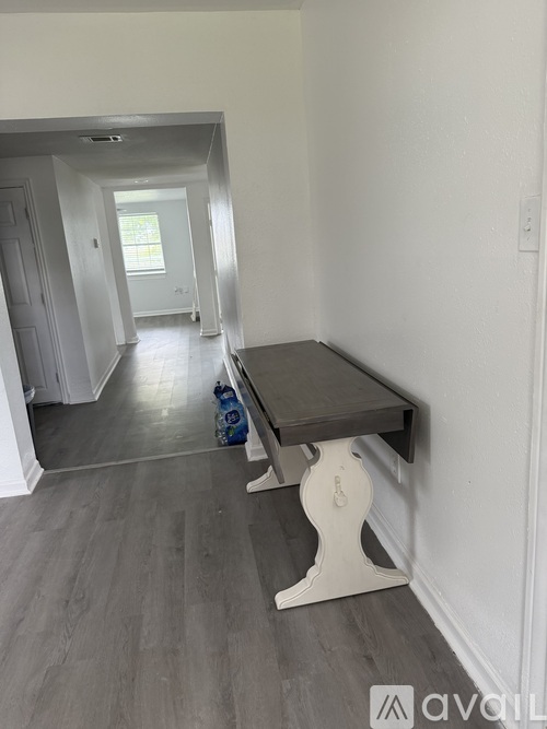 A long hallway with a bench and a door.