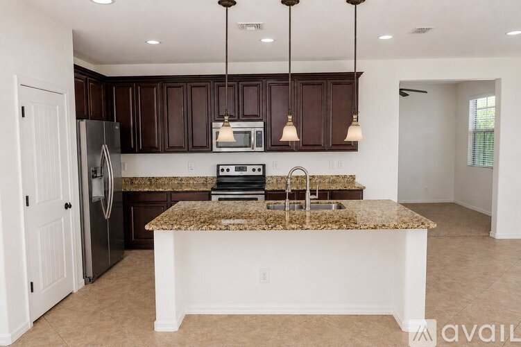 A kitchen with brown cabinets and granite countertops.
