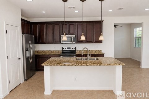 A kitchen with brown cabinets and granite countertops.