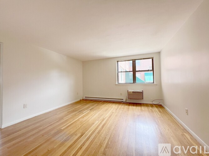 A room with wooden flooring and a window.