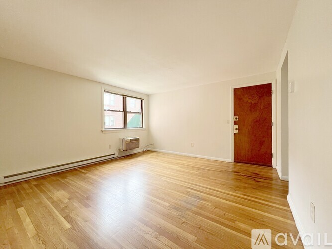 A room with wooden flooring and a window.